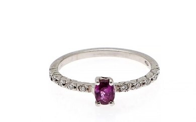 NOT SOLD. A ruby ring set with an oval-cut ruby flanked by numerous diamonds weighing...