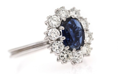 NOT SOLD. A sapphire and diamond ring set with an oval-cut sapphire encircled by numerous...