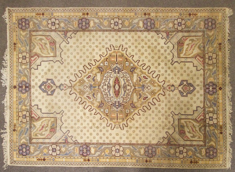 An Oriental style wool rug, cream ground with central geometric medallion